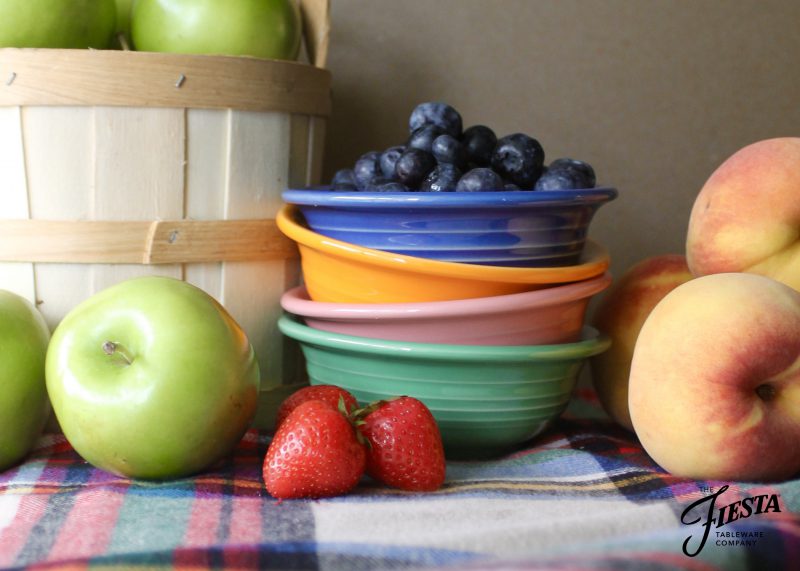 Fruit/Salsa Bowls in Lapis, Butterscotch, Peony and Meadow with blueberries, apples strawberries and peaches around them.
